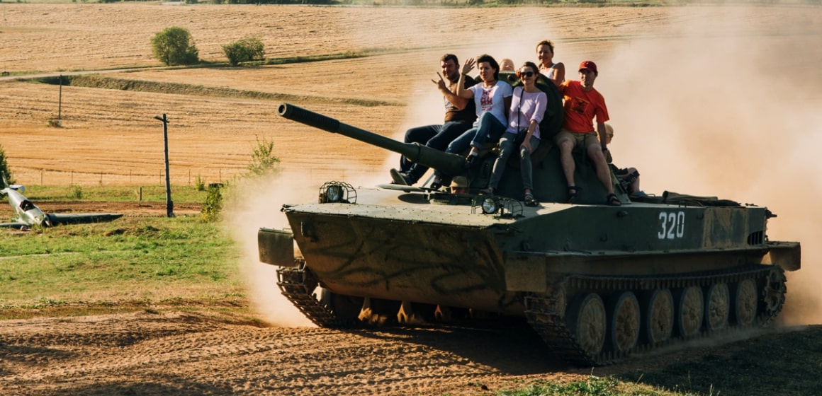 People ride a tank during Stalin Line Tour